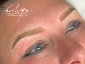 Fresh combination brows on fair skin showing fine hair strokes at bulb layered over ombré powder shading creating dimensional natural-looking texture and depth
