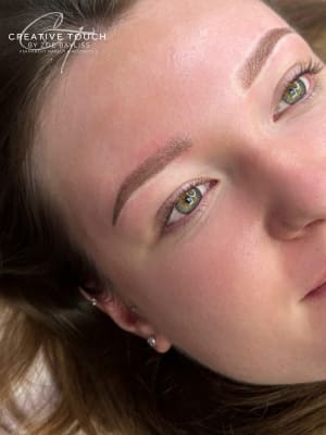 Our lovely client from the side view shows off the softness of the brows. The client is looking away from the camera. The brow area is a little red due to the client's sensitive skin. The reaction to the treatment differs for everyone.