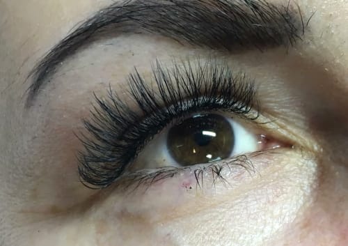 Extreme close-up of lash styling on hooded eyes to create an open-eyed look.
