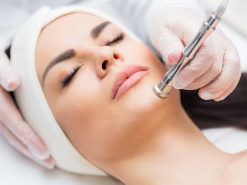 Portrait of a woman receiving microdermabrasion facial therapy.