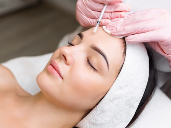 A woman receiving Botox injections to her forehead for wrinkle reduction