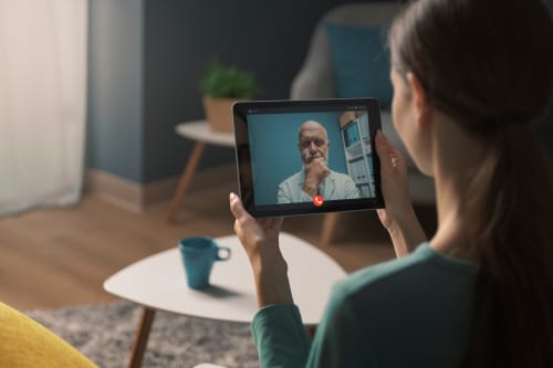 A young woman having a video call with her doctor.