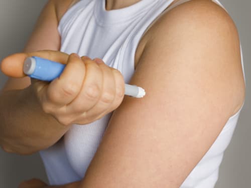 A woman injecting weight loss medication into her arm