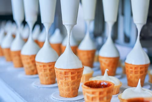 Ice cream in cones being manufactured in a food factory