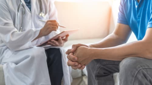 A man in a doctor's surgery undergoing a professional consultation.