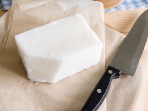 Grass-fed Irish beef tallow rendered into creamy white block, showing its natural texture