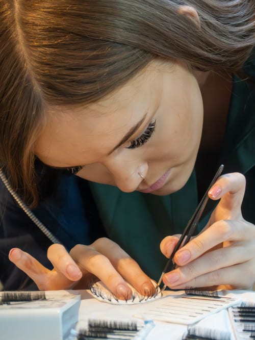 Close-up of Jessica Bayliss performing detailed lash extension work showing her steady hands and concentration