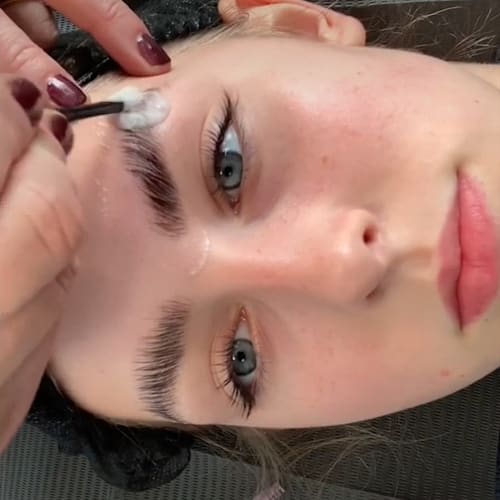 Close-up timelapse of a client receiving a laminated eyebrows treatment, showcasing the process from shaping the brows to applying the laminating solution and achieving a defined, groomed look.