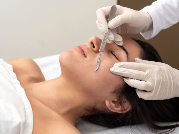 Portrait of a woman receiving dermaplaning treatment at a beauty salon